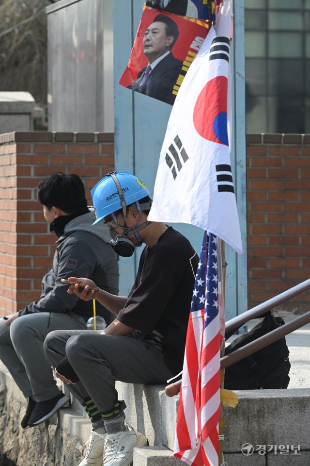 헌법재판소의 윤석열 대통령 탄핵심판 선고일인 4일, 서울 안국역 인근 거리에서 방독면을 착용한 시민이 앉아 있었다. 방독면을 쓴 이유를 묻자, 그는 "만에 하나"라고 짧게 답했다.조주현기자