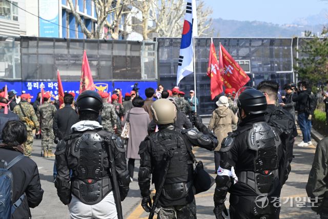 헌법재판소의 윤석열 대통령 탄핵 심판 선고일인 4일 오전, 헌법재판소 인근 폴리스라인 앞에서 전투 헬멧과 전술복 등을 착용한 시민들이 어깨에 기다란 물건을 검은 가방에 담아 이동하고 있다.조주현 기자
