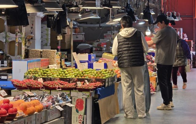 7일 인천 부평구 삼산농산물시장을 찾은 손님들이 과일 가격을 살펴보고 있다. 이정엽기자