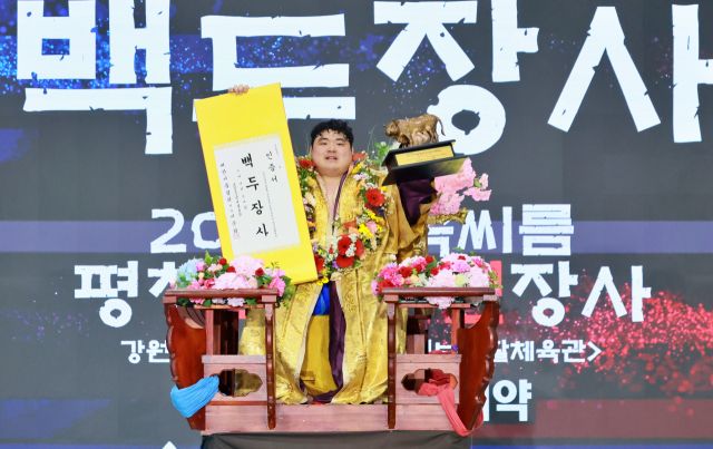 8일 강원도 평창군 진부생활체육관에서 열린 2025 민속씨름 평창오대산천장사씨름대회’에서 백두장사에 등극한 서남근이 꽃가마에 올라 황소트로피와 장사인증서를 들어보이고 있다.대한씨름협회 제공