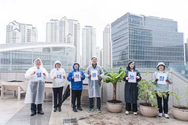 경기도의회 더불어민주당이 9일 도의회 4층 테라스에 열대작물 시범농장을 조성한 뒤 기념촬영을 하고 있다. 경기도의회 제공.