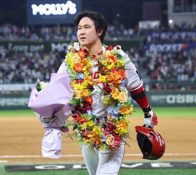 500호 홈런을 친 최정이 구단이 마련한 화환과 꽃다발을 받아들고 더그아웃으로 향하고 있다.연합뉴스