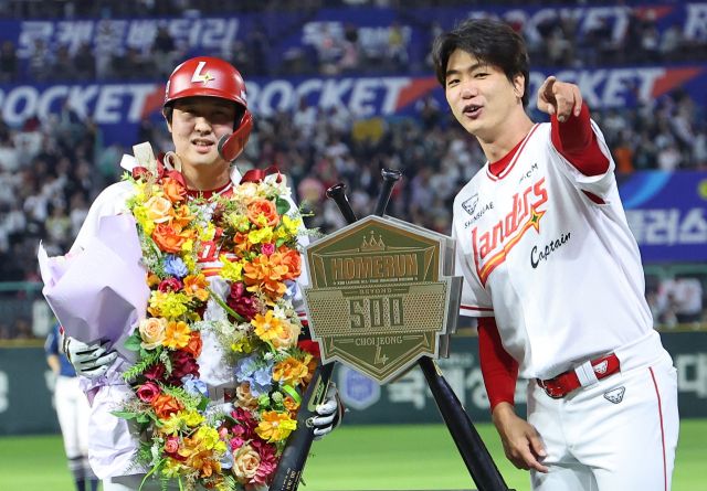 13일 열린 프로야구 NC 다이노스와의 홈 경기서 6회 KBO리그 최초 통산 500홈런을 달성한 SSG 최정(왼쪽)이 주장 김광현과 기념 조형물 앞에서 기념 촬영을 하고 있다.연합뉴스