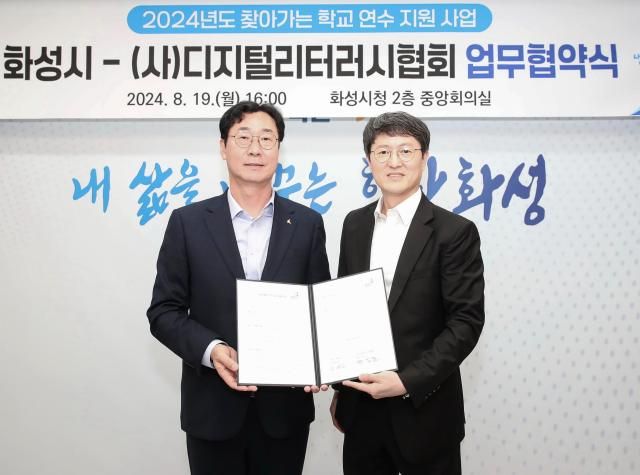 지난해 8월 화성특례시와 디지털리터리시 협회와 업무협약을 체결한 가운데 정명근 화성특례시장(왼쪽)과 박일준 디지털리터리시 협회 회장이 기념촬영을 하고 있다. 화성특례시 제공