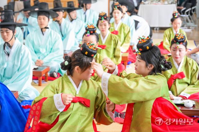 성년의날을 이틀 앞둔 17일 오전 안산시행복예절관에서 열린 '제53회 성년의날 기념 안산시 전통성년례'에서 학생들이 서로의 머리를 만져주고 있다. 관혼상제(冠婚喪祭) 중 첫 번째 예식인 전통 성년례는 성인의 상징인 갓과 족두리를 씌워주며 책임감 있는 성년으로 임명하고 책임감을 부여하는 행사다.