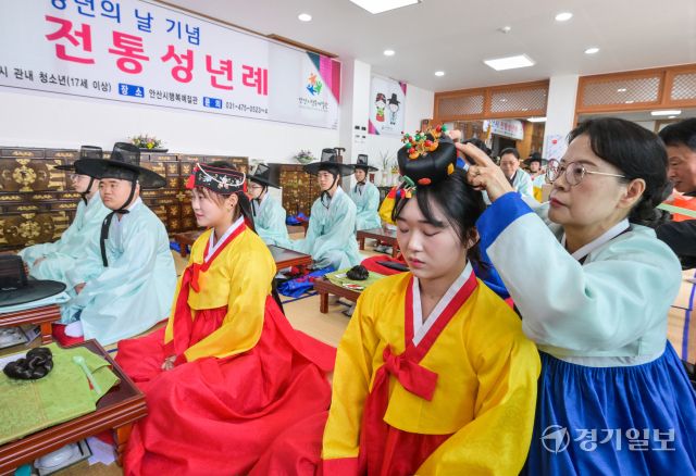 성년의날을 이틀 앞둔 17일 오전 안산시행복예절관에서 열린 '제53회 성년의날 기념 안산시 전통성년례'에서 학생들이 서로의 머리를 만져주고 있다. 관혼상제(冠婚喪祭) 중 첫 번째 예식인 전통 성년례는 성인의 상징인 갓과 족두리를 씌워주며 책임감 있는 성년으로 임명하고 책임감을 부여하는 행사다.
