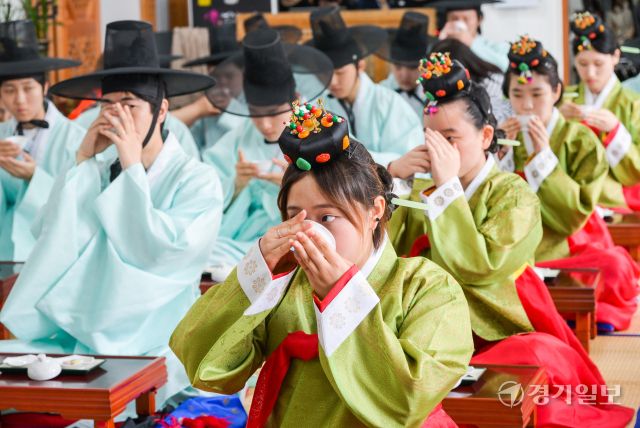 성년의날을 이틀 앞둔 17일 오전 안산시행복예절관에서 열린 '제53회 성년의날 기념 안산시 전통성년례'에서 학생들이 술마시는 예법을 배우고 있다. 관혼상제(冠婚喪祭) 중 첫 번째 예식인 전통 성년례는 성인의 상징인 갓과 족두리를 씌워주며 책임감 있는 성년으로 임명하고 책임감을 부여하는 행사다.