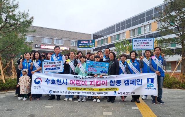 수원 파장초 앞에서 학생·학부모·교직원과 공무원 등이 ‘수호천사 어린이 지킴이 운동 합동 캠페인’을 전개하며 기념촬영을 하고 있다. 파장초 제공