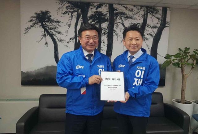 고영인 더불어민주당 중앙선거대책위원회 모두의나라위원장이 19일 윤호중 민주당 총관선대본부장에게 정책 제안서를 전달한 후 기념촬영을 하고 있다. 모두의나라위원회 제공