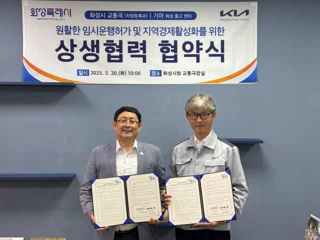 화성특례시 교통국 차량등록과가 20일 기아 화성출고센터와 원활한 임시운행허가 및 지역경제 활성화를 위한 상생협력 협약을 체결한 가운데(왼쪽부터)김성현 교통국장, 원규연 기아 화성출고센터장이 기념촬영을 하고 있다. 화성특례시 제공