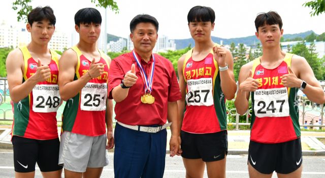 21일 밀양종합운동장에서 열린 제54회 전국종별육상대회 남고 400m 계주서 시즌 3관왕을 차지한 경기체고 선수들이 김호철 교장(가운데)과 기념촬영을 하고 있다.경기체고 제공