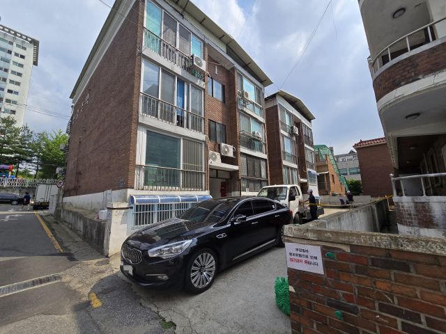 21일 수원시 장안구 한 다가구주택 외벽이 부풀어오른 가운데 공사 관계자들이 낙하물 방지망과 보조기둥 설치 작업을 진행하고 있다. 황호영기자