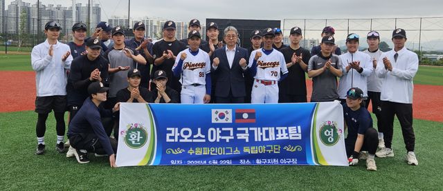 독립야구단 수원파인이그스 선수단이 22일 라오스에서 한국 야구를 배우기 위해 온 태오와 나를 환영하며 기념촬영을 하고 있다.수원BC 제공