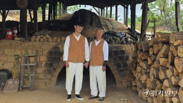 경기도 무형유산 ‘옹기장’ 전수장학생 김희건씨와 그의 할아버지이자 국가무형유산 옹기장 김일만 장인이 가마 앞에서 손을 맞잡고 있다. 윤원규기자