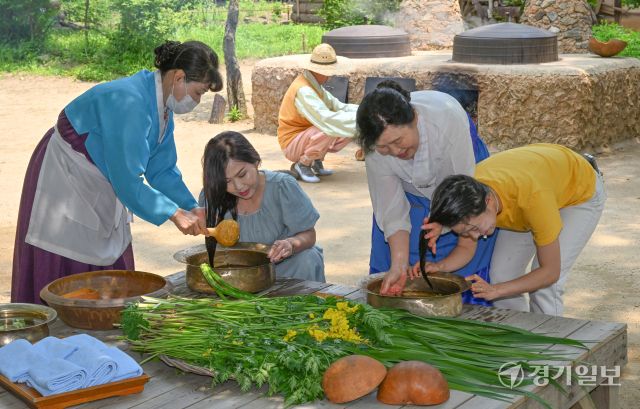 단오를 이틀 앞둔 29일 오전 용인특례시 한국민속촌에서 관광객들이 창포물에 머리감기 체험을 하고 있다. 수릿날·천중절·단양 이라고도 불리는 단오에는 남자는 씨름을 하고 여자는 창포물에 머리를 감거나 그네를 뛰며 하루를 보낸다. 김시범기자