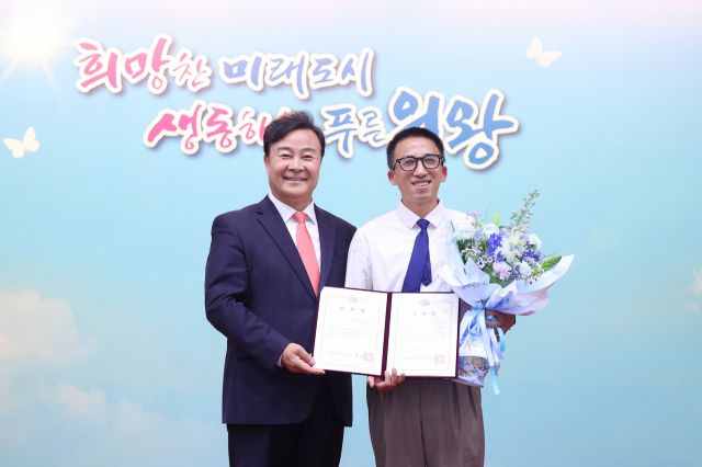 김성제 의왕시장(왼쪽)이 의왕시로 파견된 중국 센닝시 슈츠잔 사법국 과장과 기념사진을 찍고 있다. 의왕시 제공