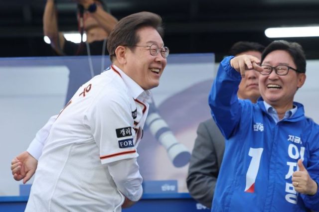 이재명 더불어민주당 대선 후보(왼쪽)가 31일 대전시청 앞 보라매공원에서 열린 유세에서 한화이글스의 전설적인 투수였던 송진우 감독의 21번 유니폼을 입고서 21대 대선 승리를 다짐하며 힘찬 투구동작을 하고 있다. 연합뉴스