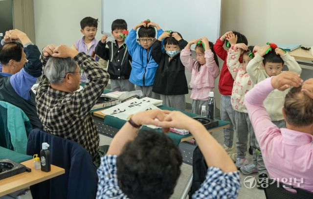 어버이날을 하루 앞둔 7일 오전 수원특례시 팔달노인복지관에서 어르신들이 아이들로부터 카네이션 선물을 받으며 환한 미소를 짓고 있다. 윤원규기자