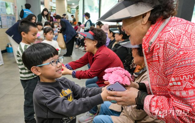 어버이날을 하루 앞둔 7일 오전 수원특례시 팔달노인복지관에서 어르신들이 아이들로부터 카네이션 선물을 받으며 환한 미소를 짓고 있다. 윤원규기자