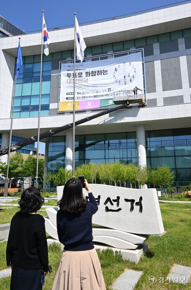 제21대 대통령선거를 27일 앞둔 7일 인천시 미추홀구 인천시 선거관리위원회 외벽에 작업자들이 대선 투표일과 사전 투표일을 알리는 대형 현수막을 설치하고 있다. 조병석기자