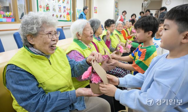 어버이날을 하루 앞둔 7일 오전 수원특례시 팔달노인복지관에서 어르신들이 아이들로부터 카네이션 선물을 받으며 환한 미소를 짓고 있다. 윤원규기자