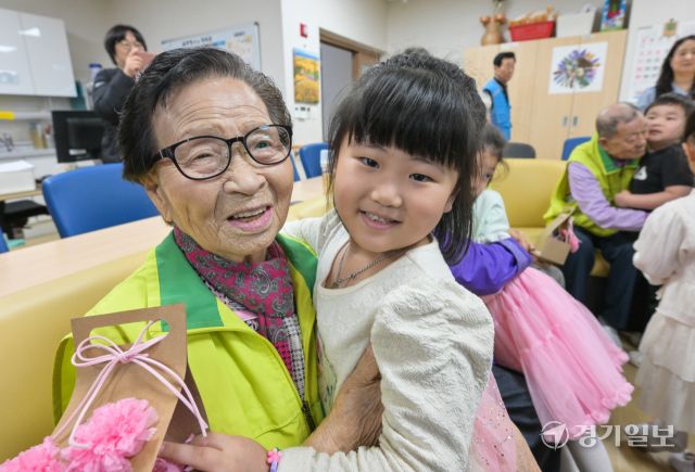 어버이날을 하루 앞둔 7일 오전 수원특례시 팔달노인복지관에서 어르신들이 아이들로부터 카네이션 선물을 받으며 환한 미소를 짓고 있다. 윤원규기자