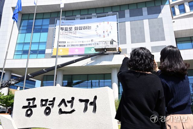 제21대 대통령선거를 27일 앞둔 7일 인천시 미추홀구 인천시 선거관리위원회 외벽에 작업자들이 대선 투표일과 사전 투표일을 알리는 대형 현수막을 설치하고 있다. 조병석기자