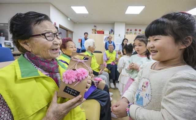 어버이날을 하루 앞둔 7일 오전 수원특례시 팔달노인복지관에서 어르신들이 아이들로부터 카네이션 선물을 받으며 환한 미소를 짓고 있다. 윤원규기자