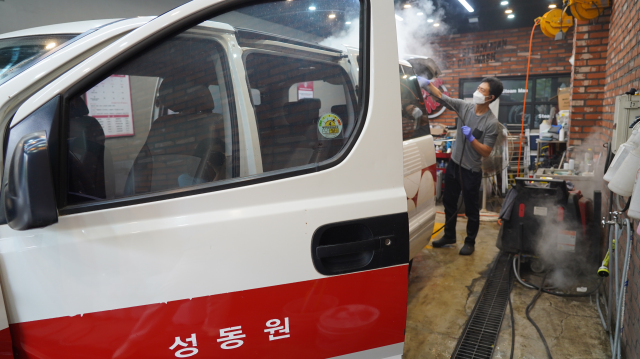 최근 차량 스팀세차 전문업체 직원들이 ‘사회복지시설 이동지원 차량 소독 지원사업’에 참여한 장애인 거주 시설 12인승 차량을 청소하고 있다. 인천사서원 제공