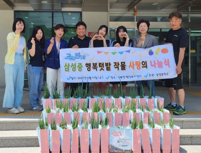 삼성중학교 교직원과 핵생 등 관계자들이 채소꾸러미를 전달하며 기념촬영을 하고 있다.포천시제공.