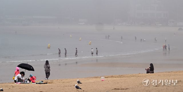무더운 날씨를 보인 18일 오후 인천 을왕리 해수욕장에 짙은 해무가 깔린 가운데 피서객들이 물놀이를 즐기고 있다. 조병석기자 .