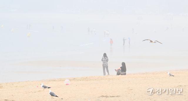 무더운 날씨를 보인 18일 오후 인천 을왕리 해수욕장에 짙은 해무가 깔린 가운데 피서객들이 물놀이를 즐기고 있다. 조병석기자 .