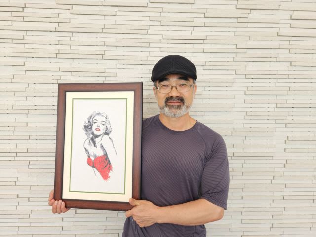 최신택 씨가 자신이 만든 십자수 작품을 들고 미소를 짓고 있다. 황남건기자