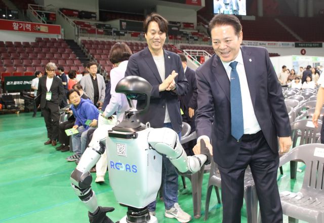 안양스마T움 축제에서 최대호 안양시장(오른쪽 첫번째)이 휴머노이드 로봇과 악수를 하고 있다. 안양시 제공.