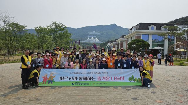 포천시종합사회복지관 노인맞춤돌봄서비스를 이용중인 어르신36명과 생활지원사19명이 봄나들이 중 베로니아새정원에서 기념촬영을 하고 있다. 포천시종합사회복지관제공.