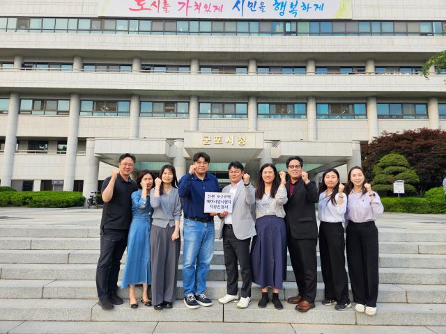 군포산본신도시 선도지구인 9-2구역 주민대표단이 예비사업시행자 지정신청에 앞서 기념촬영을 하고 있다. 군포시 제공