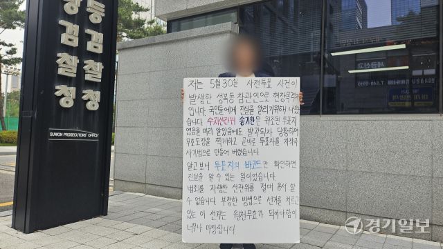 용인 성북동 사전투표소 참관인이 2일 오전 수원지검 앞에서 선관위 대응을 지적하는 호소문을 들고 1인 시위를 벌이고 있다. 송상호기자