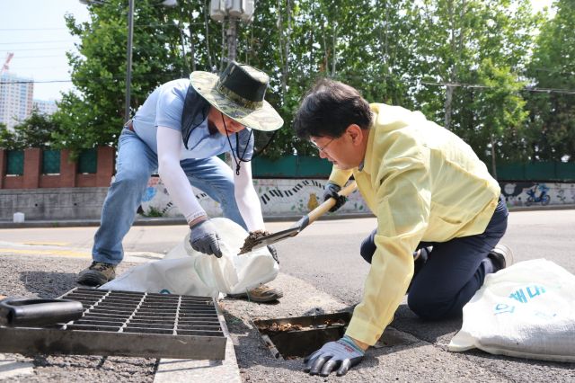안치권 의왕시부시장(오른쪽)이 경기도 및 시 관계자들과 함께 빗물받이 상태를 점검한 후 준설작업을 실시하고 있다. 의왕시 제공