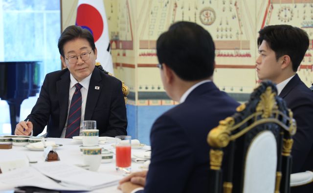 이재명 대통령이 22일 한남동 관저에서 열린 여야 지도부와의 오찬에서 국민의힘 송언석 원내대표(뒷모습)의 발언을 듣고 있다. 오른쪽은 김용태 비대위원장. 연합뉴스