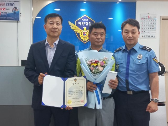 인천해양경찰서가 23일 인천 중구 인항파출소에서 107태성호 장복훈(가운데) 선장에게 감사장을 전달하고 기념사진을 촬영하고 있다. 인천해양경찰서 제공