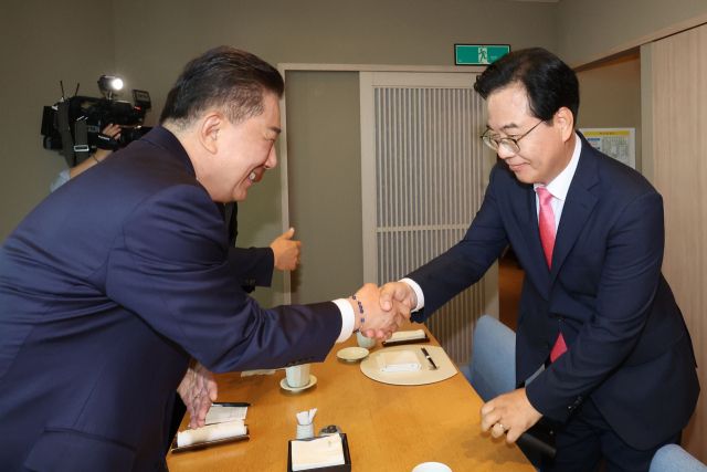 26일 더불어민주당 김병기 더불어민주당 원내대표(왼쪽)와 국민의힘 송언석 원내대표가 서울 여의도 한 식당에서 열린 양당 오찬 회동에서 악수하고 있다. 연합뉴스