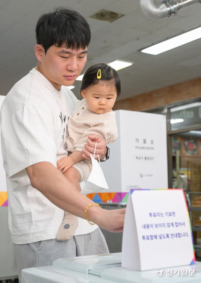 제21대 대통령 선거일인 3일 오전 광명시 소하동 한 음식점에 마련된 소하2동 제4투표소에서 한 유권자가 아이를 안고 투표하고 있다. 윤원규기자