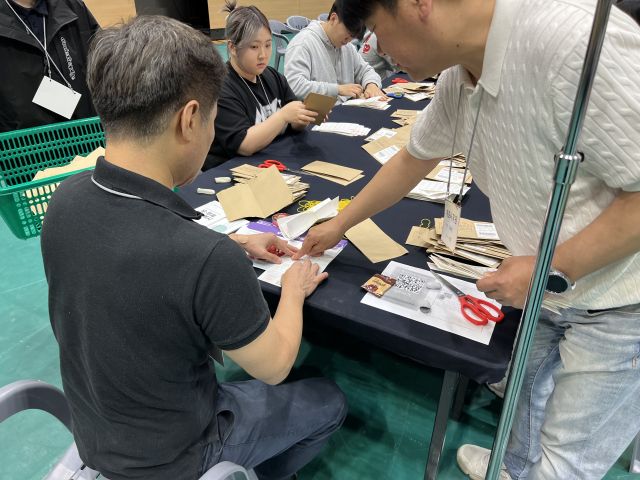 3일 제21대 대통령 선거 개표가 진행 중인 수원종합운동장 실내체육관에서 선관위 직원이 잘린 투표 용지를 테이프로 붙이고 있다. 박소민기자