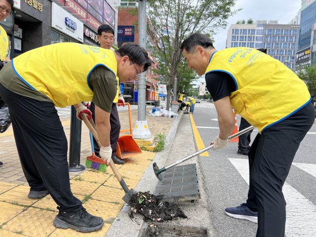 지난 29일 수원특례시 권선구에서 열린 빗물 배수구 정비 자원봉사에 나선 참가자들. 하나님의 교회 제공