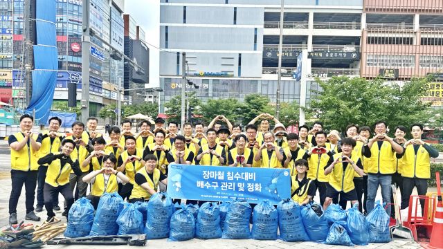 지난 29일 수원특례시 권선구에서 열린 빗물 배수구 정비 자원봉사에 나선 참가자들이 기념촬영을 하고 있다. 하나님의 교회 제공