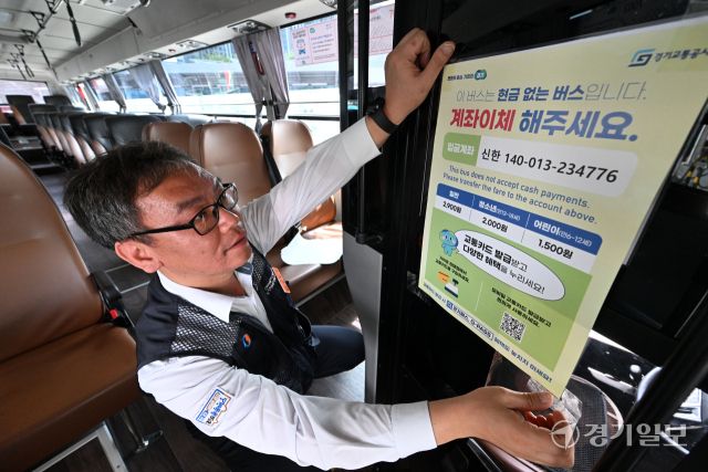 경기도가 시내버스 요금 관리 효율화, 배차 정시성 확보, 안전사고 방지 등을 위해 7월 1일부터 도내 4개 시 5개 노선을 대상으로 '현금없는 버스'를 시범 운영한다. 첫 운행일을 하루 앞둔 30일 수원남부공영주차장에서 관계자가 버스에 안내문을 부착하고 있다. 김시범기자