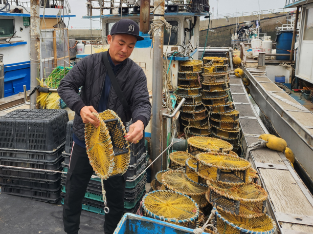 지난 3월 인천 옹진군 영흥도에서 만난 하도근씨(42)가 어선 위에서 통발을 정리하고 있다. 황남건기자