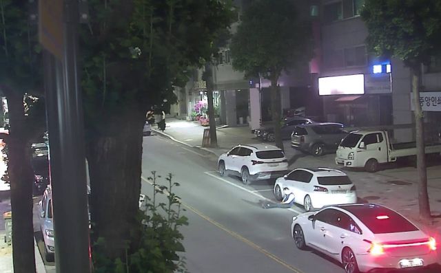 이천시가 차도를 향해 다리를 쭉 뻗은 채 위험하게 앉아 있는 주취자를 보호한 차량 운전자를 포상하기 위해 찾고 있다. 사진은 CCTV 속 해당 영상. 이천시 제공