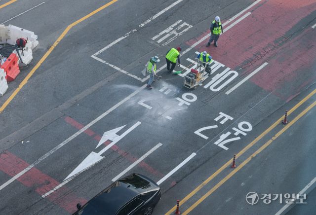 수원특례시 장안구 복합쇼핑몰 스타필드 수원 앞 대로에 ‘광교’ 방면임을 나타내는 도로노면표지가 엉터리 한글로 표기돼 있어 시의 부실한 도로 관리 실태가 도마에 오르고 있다. ‘가’ 사이에 ㅎ자가 ㅗ,ㅏ,ㅇ 자를 대체하며 ‘광’자, ㄱ자와 ㅛ 자가 기괴하게 조합된 ‘교’ 자로 돼있다. 사진은 지난 8일 오후 6시5분께 작업자가 문제의 표기를 지우고 있는 모습. 윤원규기자