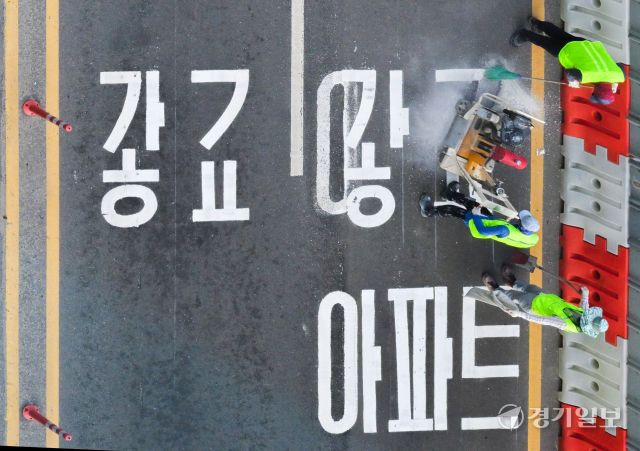 수원특례시 장안구 복합쇼핑몰 스타필드 수원 앞 대로에 ‘광교’ 방면임을 나타내는 도로노면표지가 엉터리 한글로 표기돼 있어 시의 부실한 도로 관리 실태가 도마에 오르고 있다. ‘가’ 사이에 ㅎ자가 ㅗ,ㅏ,ㅇ 자를 대체하며 ‘광’자, ㄱ자와 ㅛ 자가 기괴하게 조합된 ‘교’ 자로 돼있다. 사진은 지난 8일 오후 6시5분께 작업자가 문제의 표기를 지우고 있는 모습. 윤원규기자